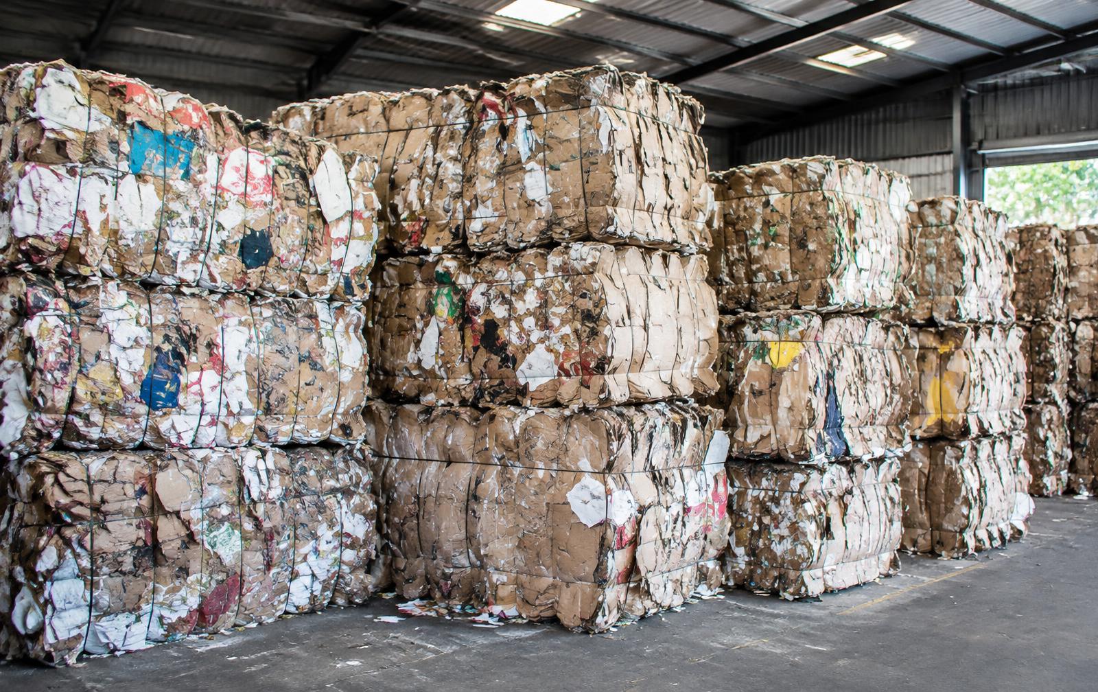 Compressed waste paper and cardboard bales stacked in a warehouse
